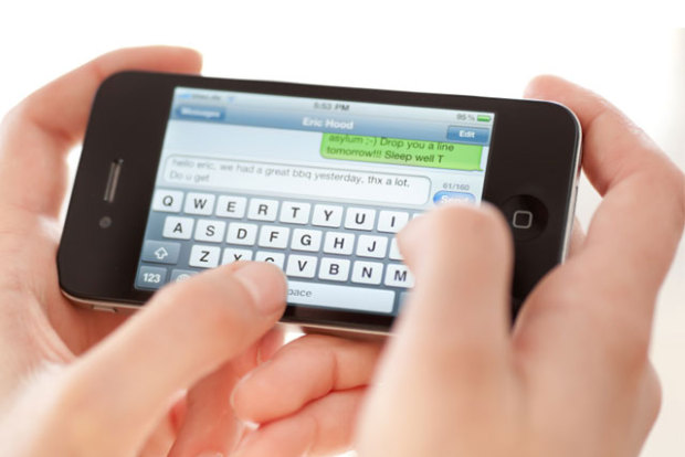 Hands holding phone with Thumbs Typing
